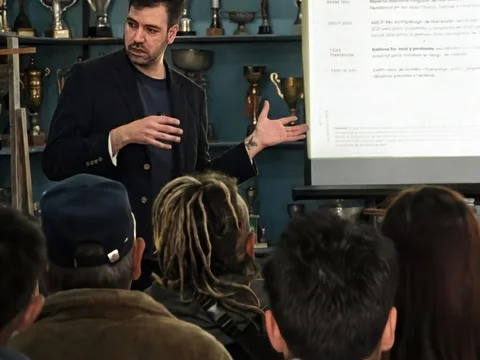 Nicolás Olave expone ante la sala del taller de marca territorial de La Higuera, con el público sentado de espaldas