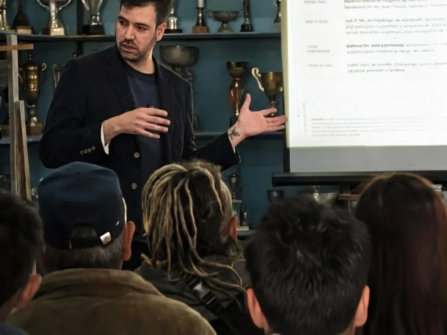 Nicolás Olave expone frente a la sala y la pantalla, en el taller de marca territorial de La Higuera, Coquimbo