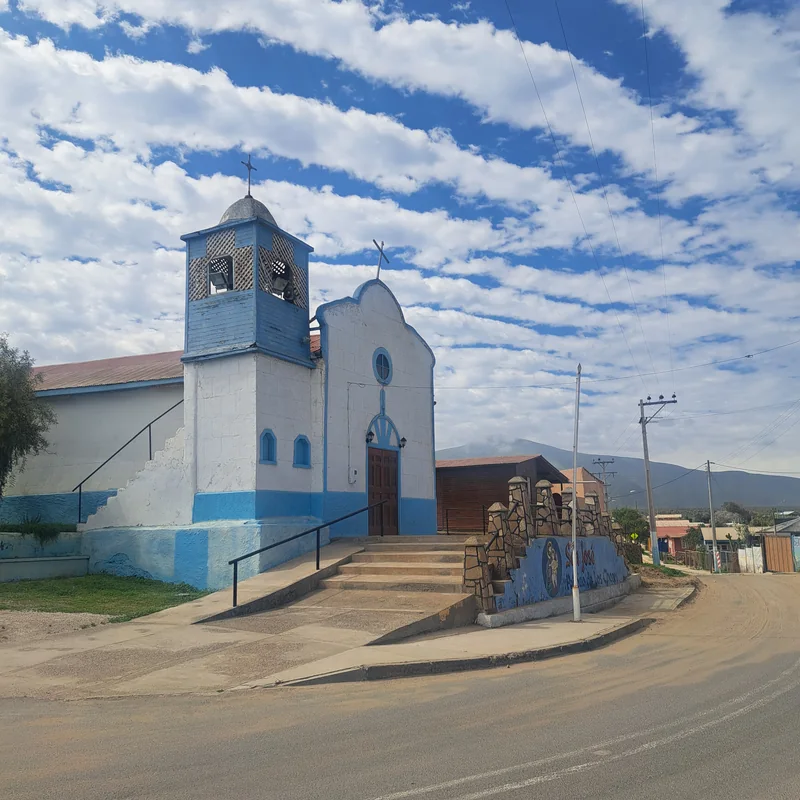Capilla de La Higuera, con su torre campanario y el mural en la escalinata de acceso